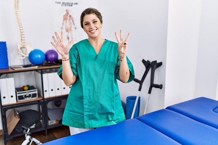 young hispanic woman wearing physiotherapist uniform standing clinic showing pointing up with fingers number eight while smiling confident happy 839833 4087